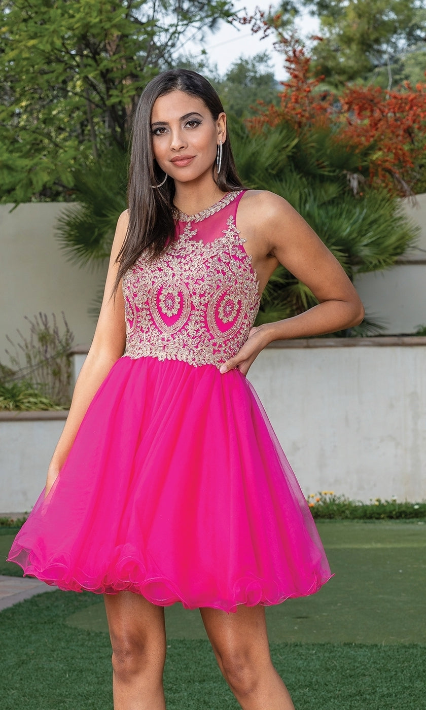 A woman stands outdoors among shrubs and trees wearing the Beaded Embroidered Lace Short Babydoll Party Dress, featuring a pink tulle skirt and a bodice with intricate gold embroidery and beading.