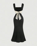 A black mermaid dress featuring a prominent white bow at the back, elegantly designed for formal occasions