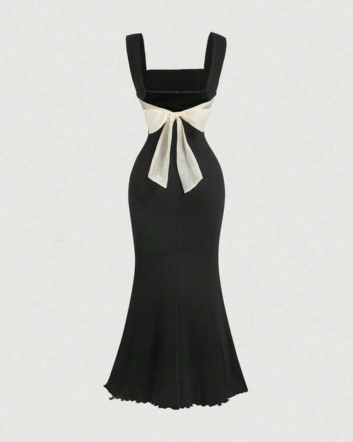 A black mermaid dress featuring a prominent white bow at the back, elegantly designed for formal occasions
