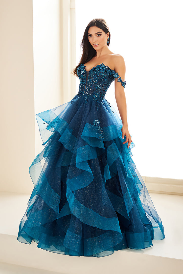 Make a statement in the Ellie Wilde EW35084 prom dress. Featuring an off-the-shoulder top, shimmer sequin lace and ruffle detail, the dress offers a timeless and sophisticated look perfect for the big night. Keep it classic in this classic formal gown.

Sizes: 00-24

Colors: Bluebell, Diamond White, Dusty Rose/Gold, Emerald, Hot Pink, Lavender, Light Pink, Light Yellow, Navy, Red, Royal, Silver, Teal, Wine&nbsp;
