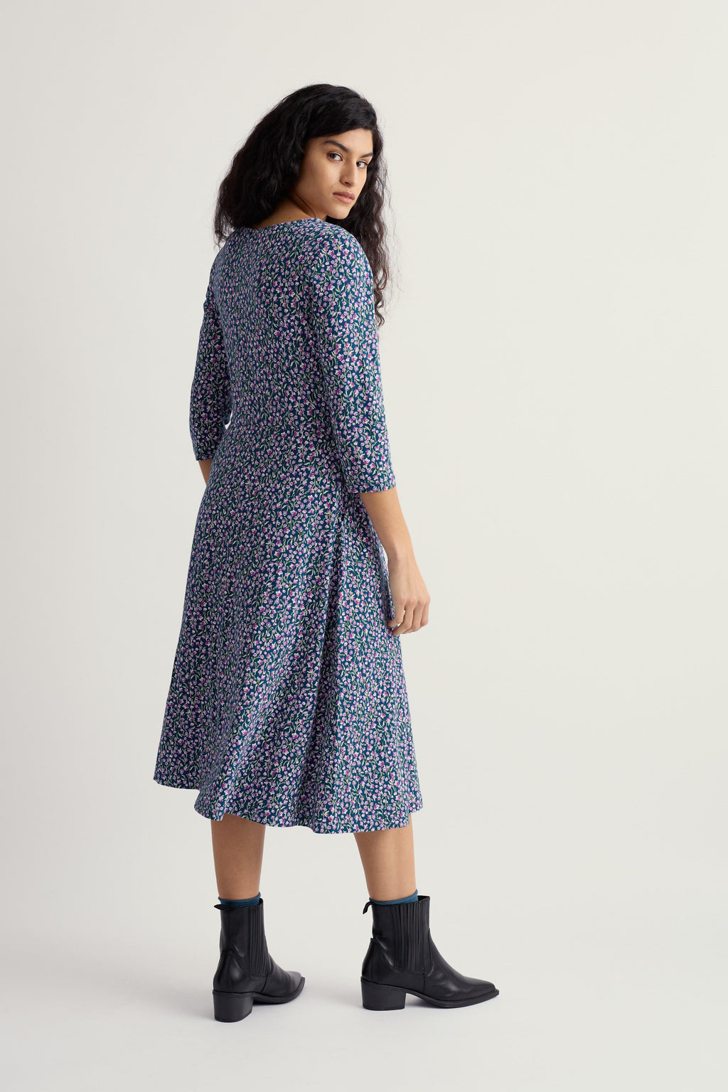 Woman wearing a blue floral dress on a white background